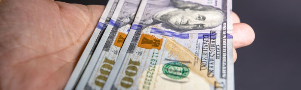 hundred dollar bills sitting on someone's open hand.